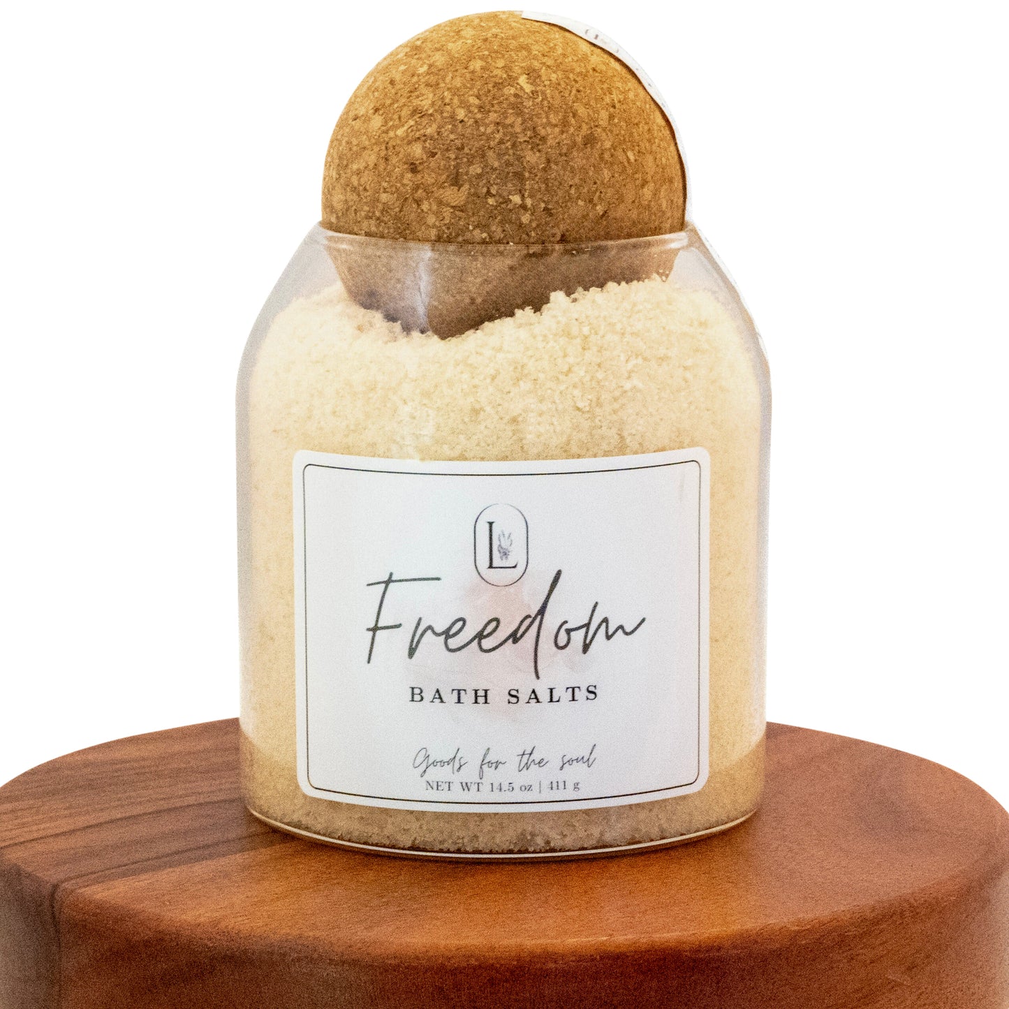 Lucille Lehr's 'Freedom' Bath Salts: Refresh your senses with the 'Freedom' bath salts, crafted to provide a soothing and revitalizing experience. Packaged in a clear jar with a rustic wooden sphere lid, these bath salts are perfect for relaxing and nourishing the soul, bringing tranquility to your self-care routine.