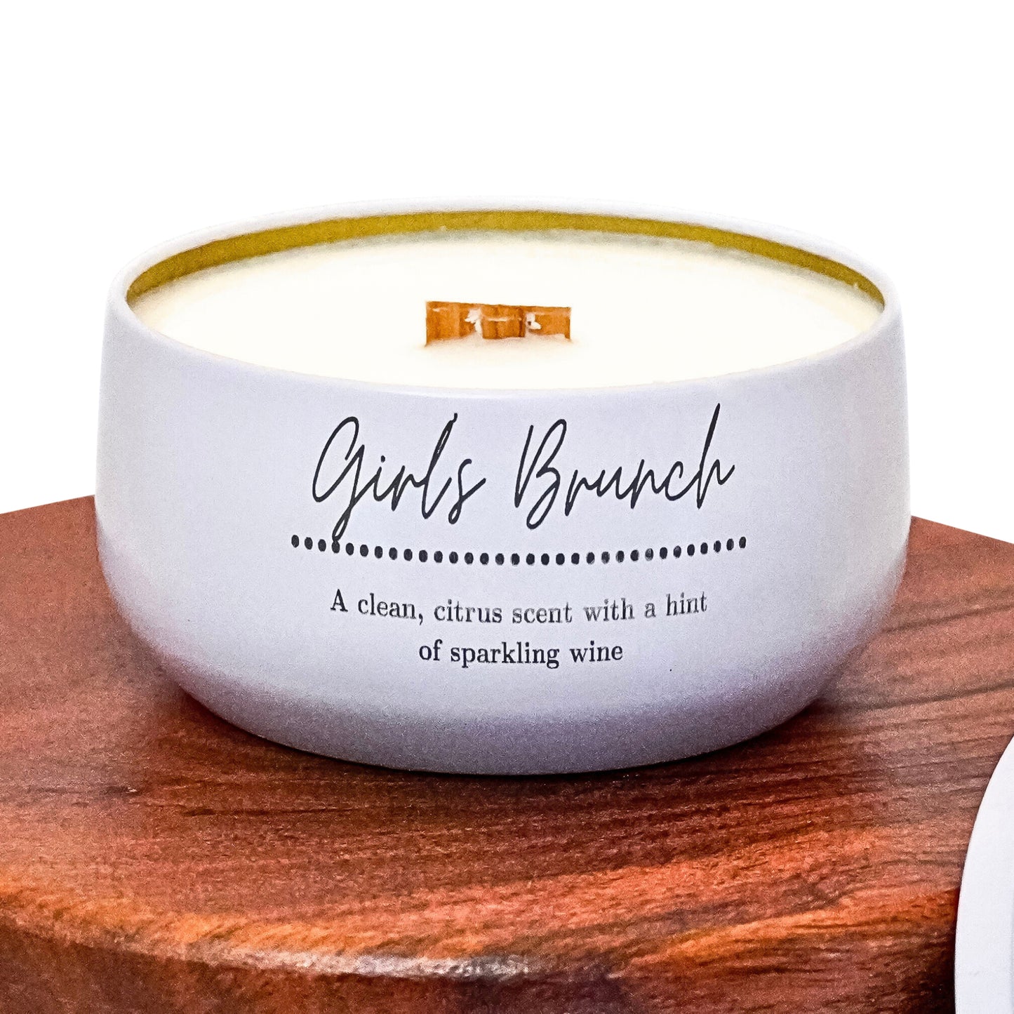 Lucille Lehr's 'Girls Brunch' Candle: Brighten your space with the refreshing 'Girls Brunch' candle, featuring a clean, citrus scent with a subtle hint of sparkling wine. Packaged in a white tin with a wooden wick that crackles gently, this candle brings a lively and uplifting aroma, perfect for any gathering or personal relaxation.