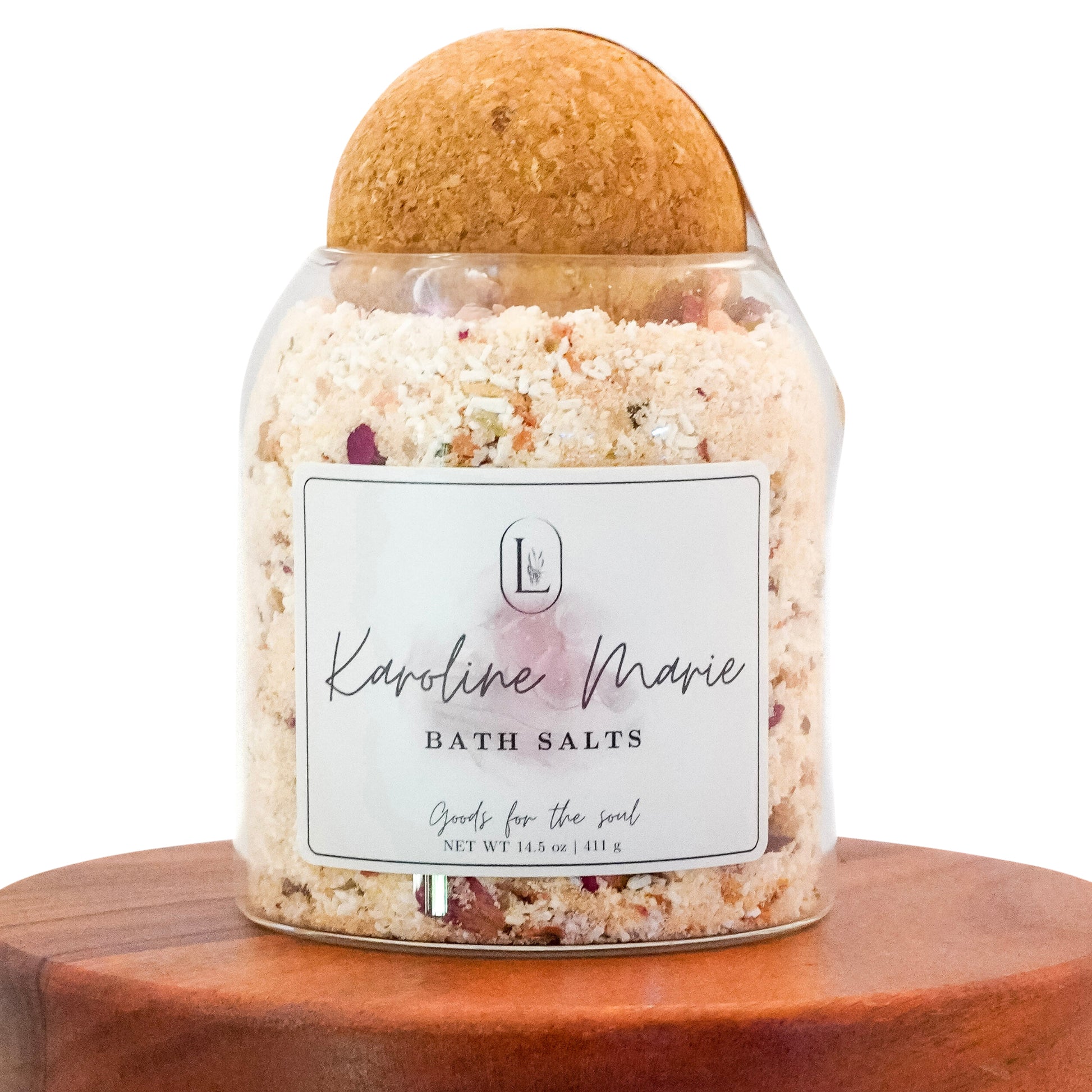 Lucille Lehr's 'Karoline Marie' Bath Salts: Embrace relaxation with the 'Karoline Marie' bath salts, a luxurious blend designed to nourish the soul. Housed in a clear jar with a natural wooden sphere lid, these salts feature a mix of soothing ingredients to elevate your bathing experience, adding elegance and tranquility to any self-care routine.